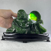 Natural Dark Green Serpentine Siting Milo Buddha with Waving Fan with Wooden Stand Display 765.0g 180.0 by 90.0 by 115.0mm - Huangs Jadeite and Jewelry Pte Ltd