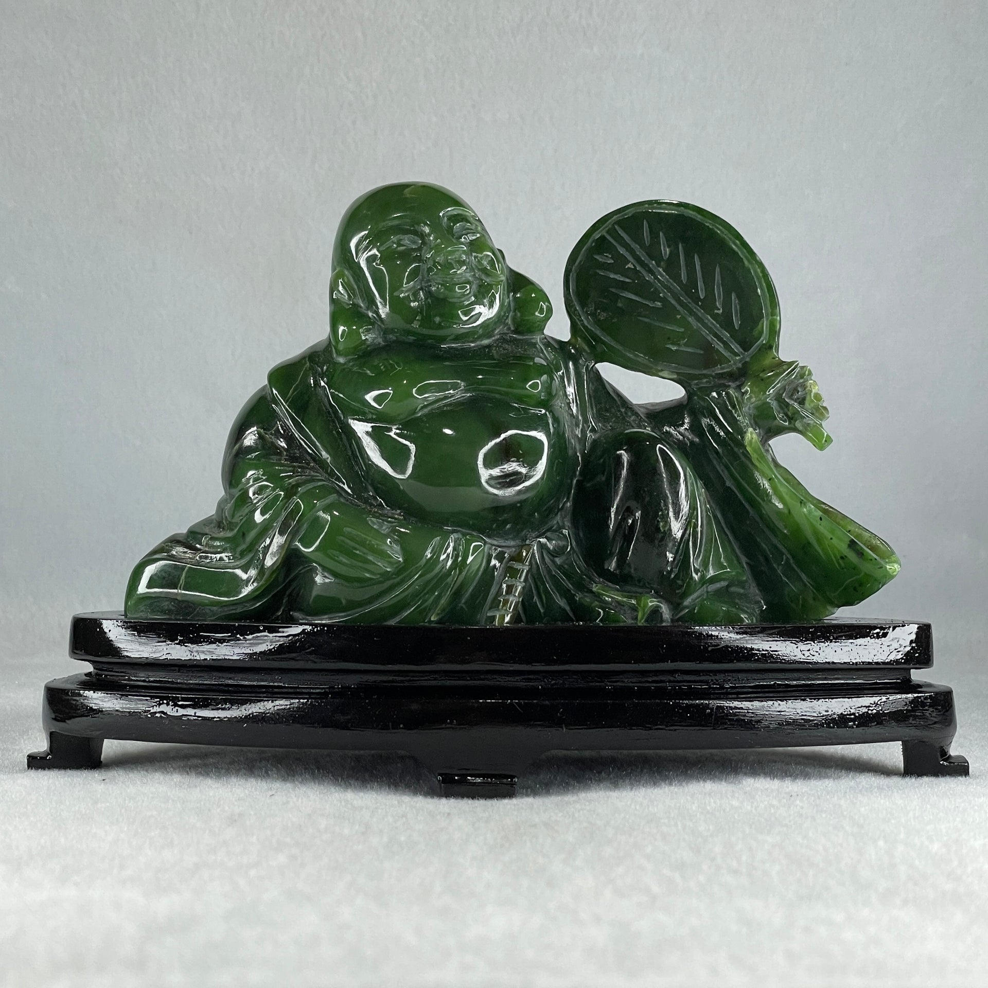 Natural Dark Green Serpentine Siting Milo Buddha with Waving Fan with Wooden Stand Display 765.0g 180.0 by 90.0 by 115.0mm - Huangs Jadeite and Jewelry Pte Ltd