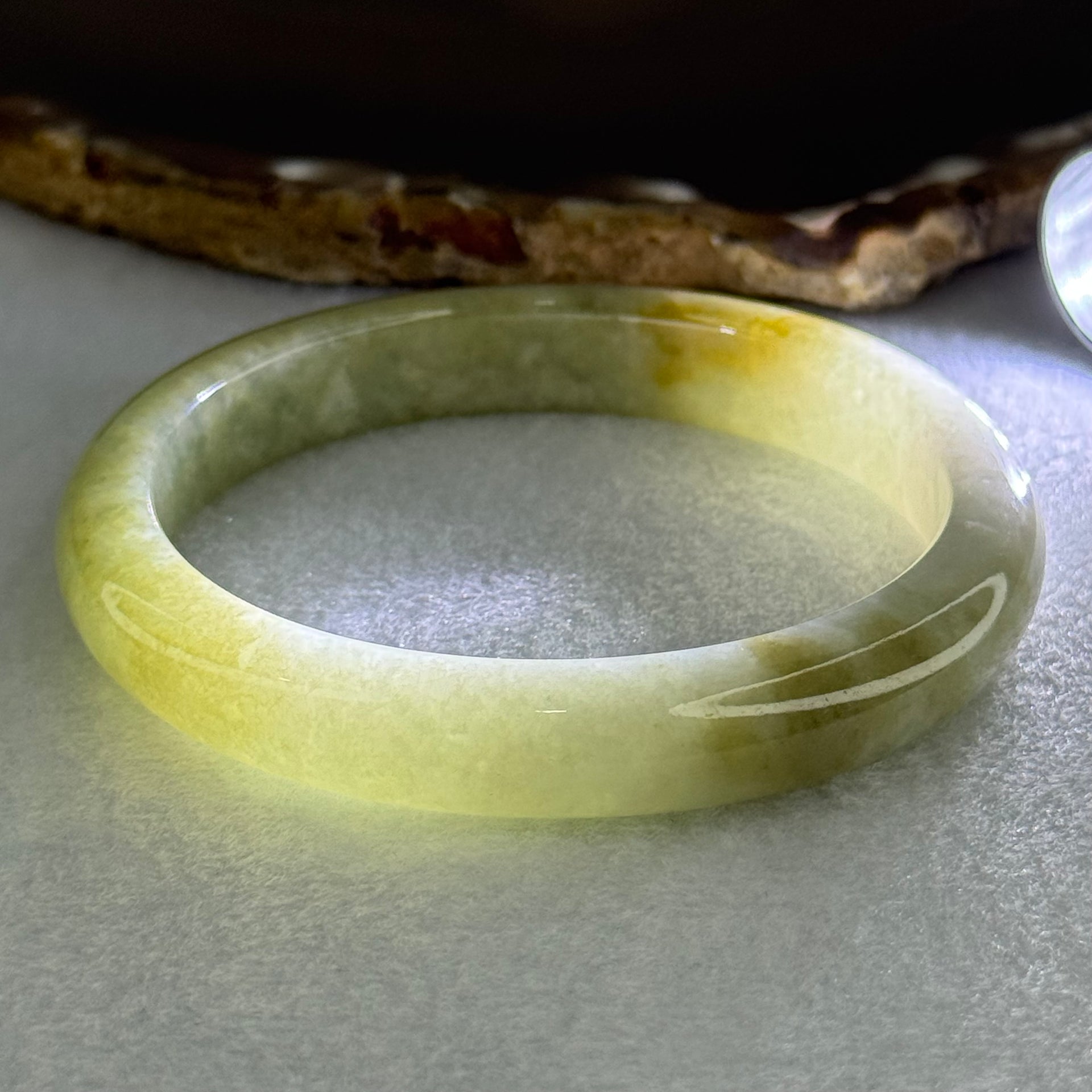 Type A Yellowish Green Lavender Jadeite Oval Bangle Internal Diameter 58.5mm 67.31g 10.7 by 8.1mm (Very Slight Fine Internal Line) - Huangs Jadeite and Jewelry Pte Ltd