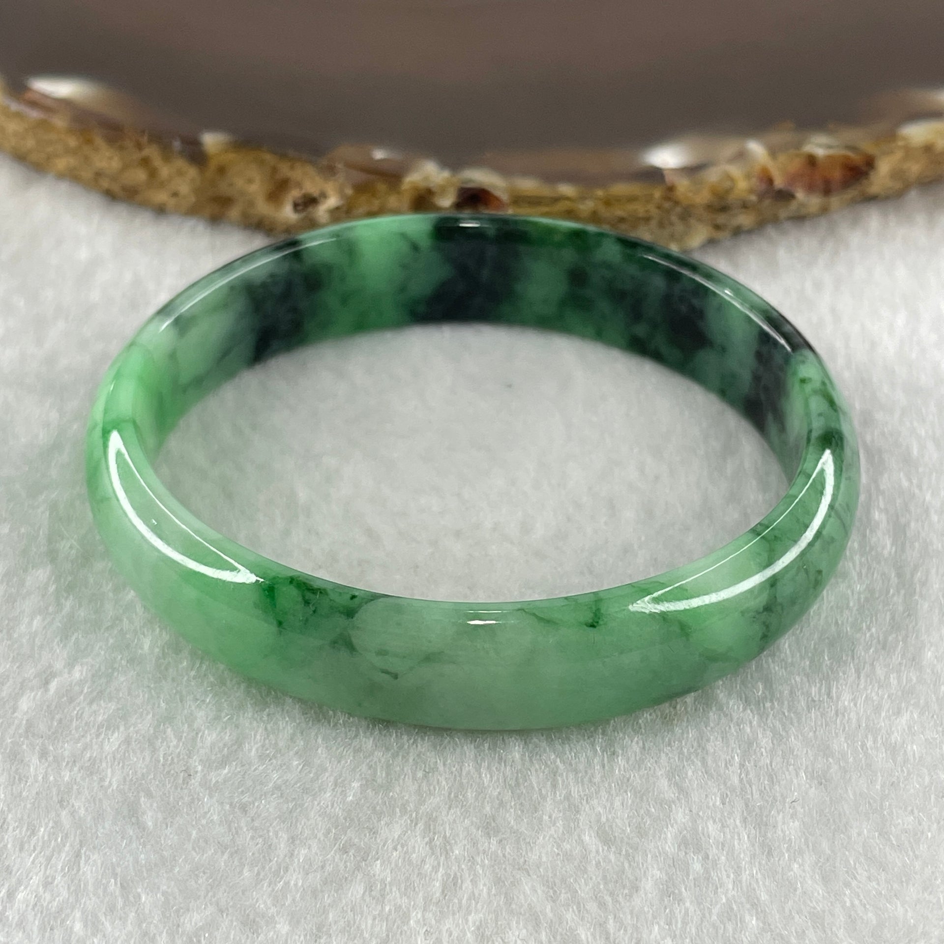 Type A Natural Old Mine Spicy Green with Dark Green Piao Hua Flora Jadeite Oval Bangle 26.28g 131.60cts Inner Diameter 52.55mm 46.90 by 5.40mm with NGI Cert 63804952 (Very Very Slight Internal Lines) - Huangs Jadeite and Jewelry Pte Ltd