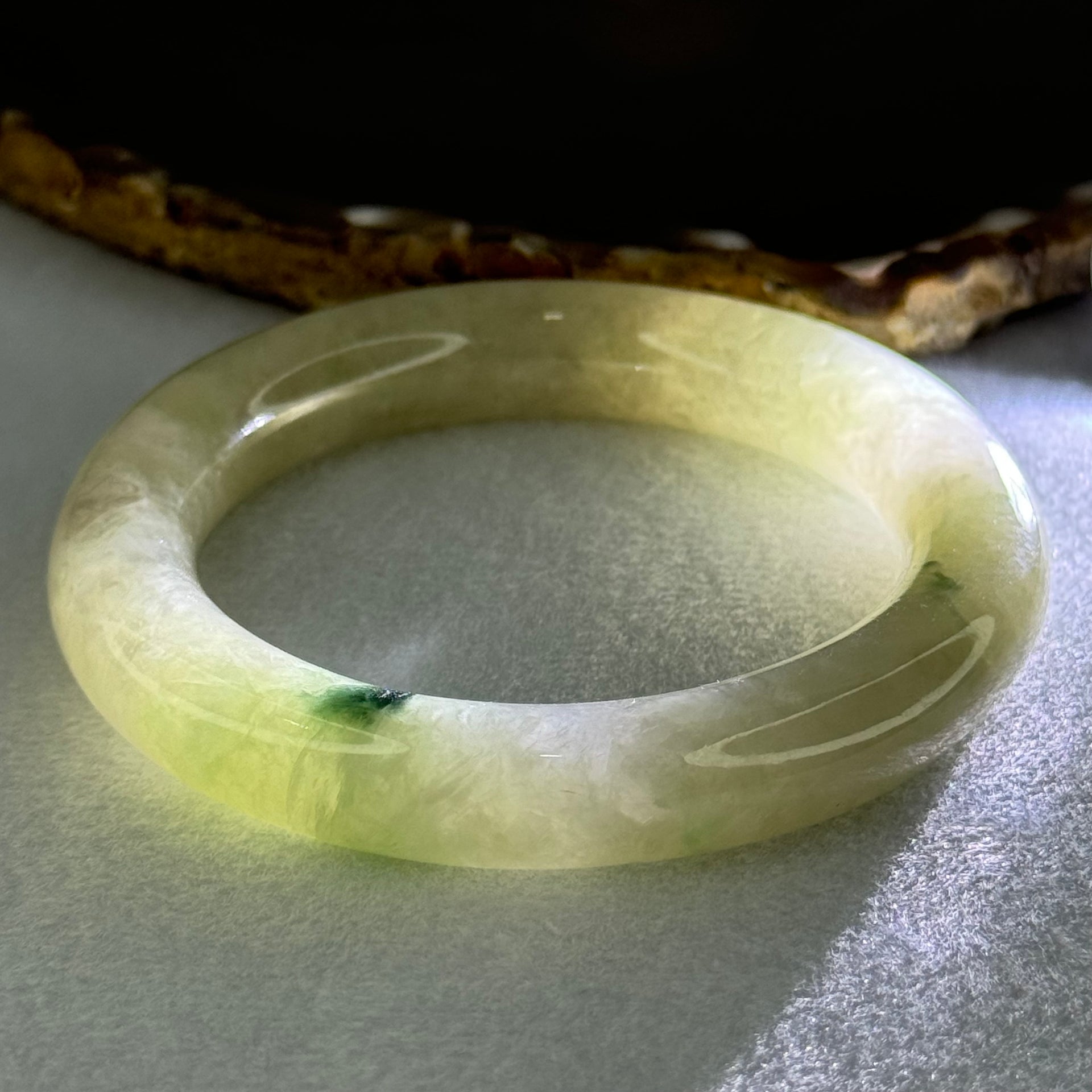 Type A Translucent Semi Icy Light Yellowish Green with Moss Green Patch Jadeite Bangle Internal Diameter 55.3mm 76.40g 12.3 by 11.6mm (Very Slight External Rough) - Huangs Jadeite and Jewelry Pte Ltd