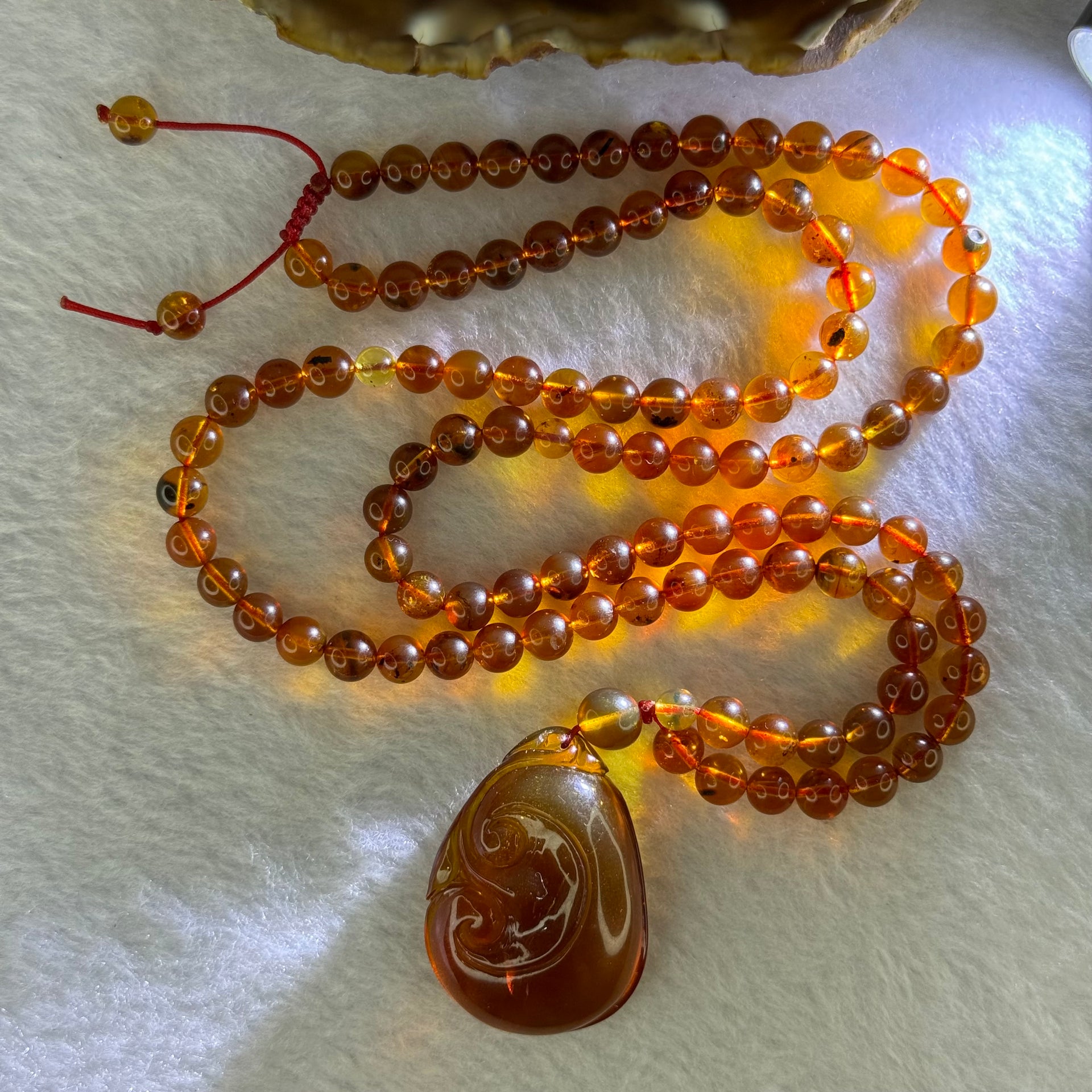 Natural Cognac Amber Ruyi Pendent 37.7 by 27.0 by 12.2mm in Amber Beads Necklace 6.3mm 105 Beads Total 19.80g - Huangs Jadeite and Jewelry Pte Ltd
