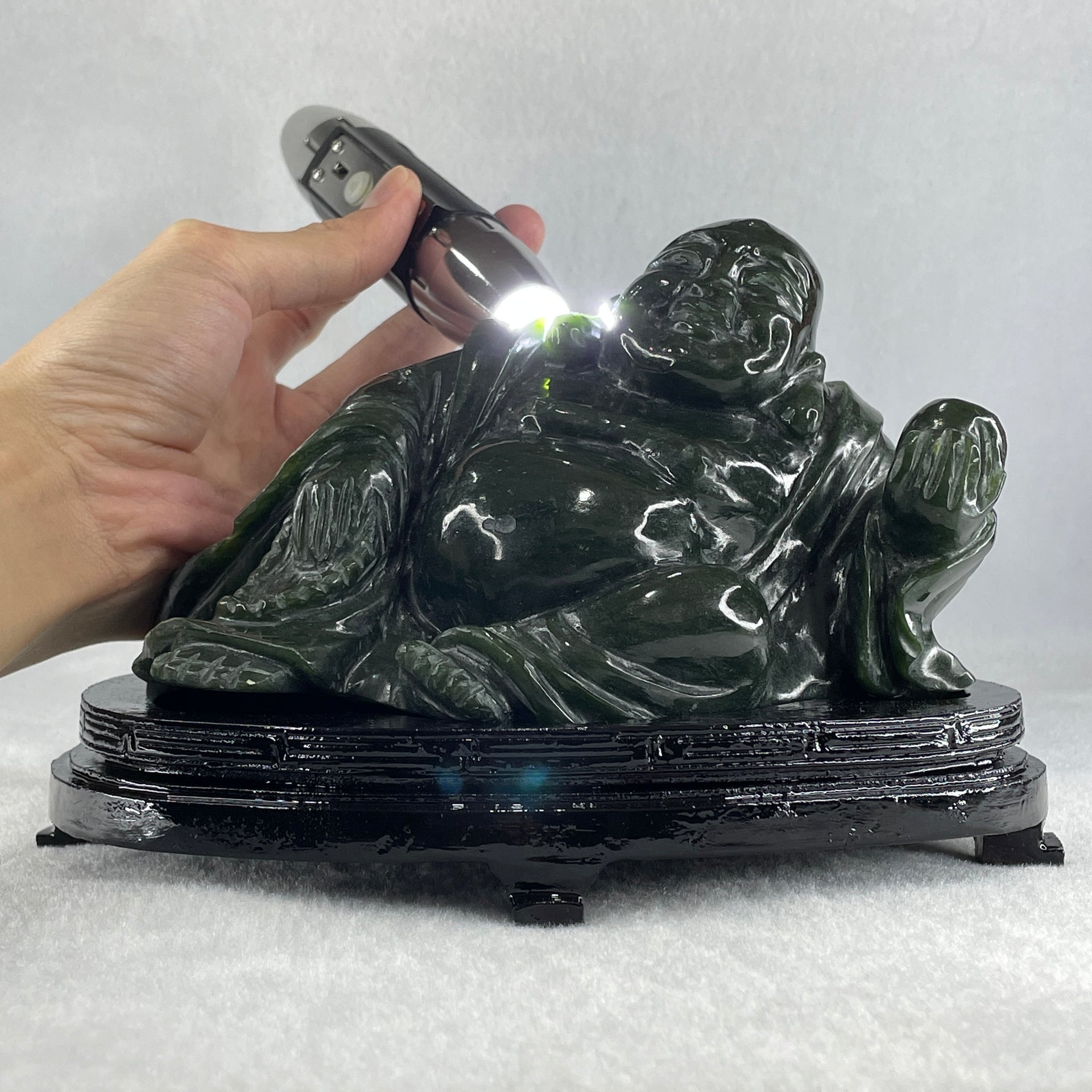 Natural Dark Green Serpentine Laughing Milo Buddha with Wealth Pot with Wooden Stand Display 1,656.6g 190.0 by 133.0 by 127.0mm - Huangs Jadeite and Jewelry Pte Ltd