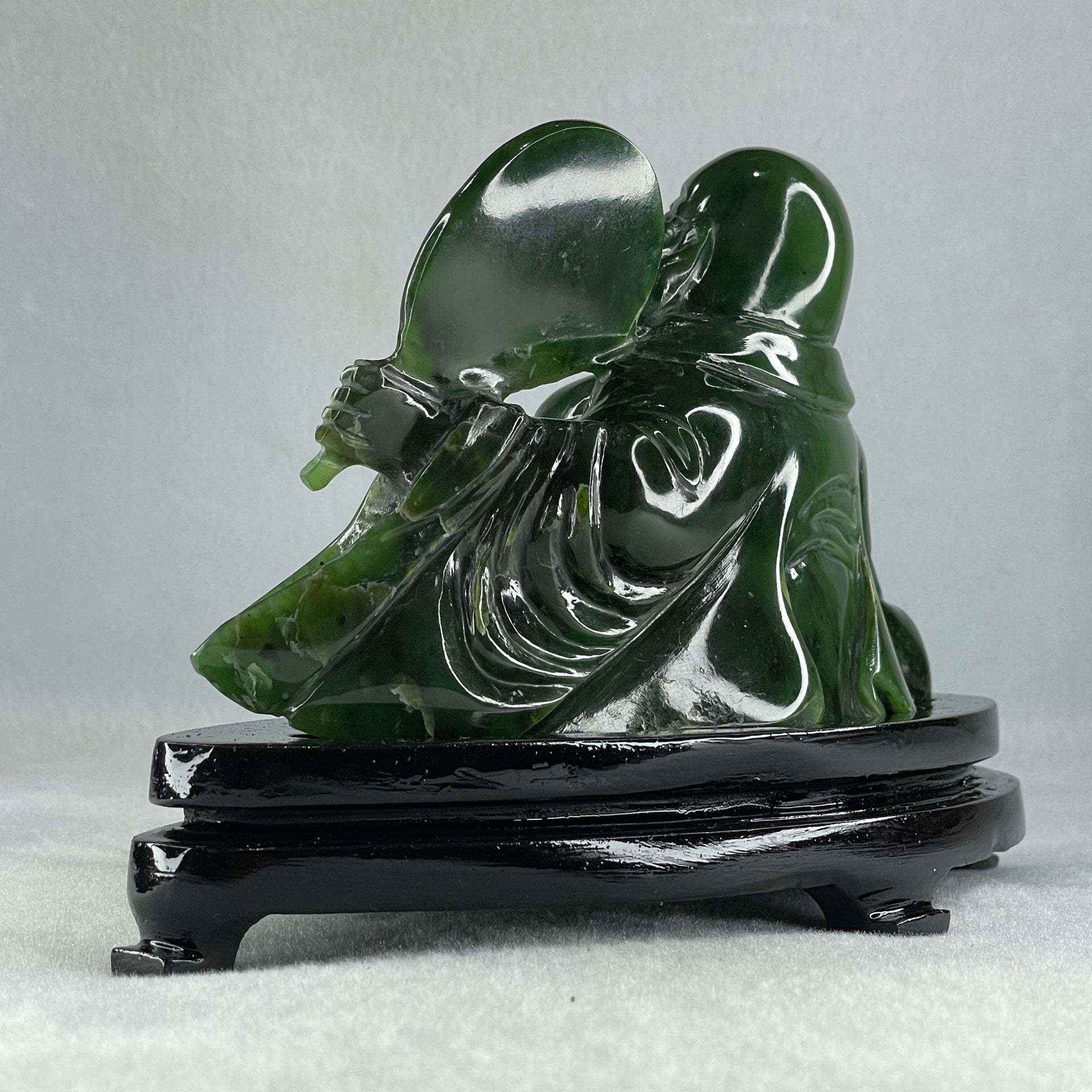 Natural Dark Green Serpentine Siting Milo Buddha with Waving Fan with Wooden Stand Display 765.0g 180.0 by 90.0 by 115.0mm - Huangs Jadeite and Jewelry Pte Ltd