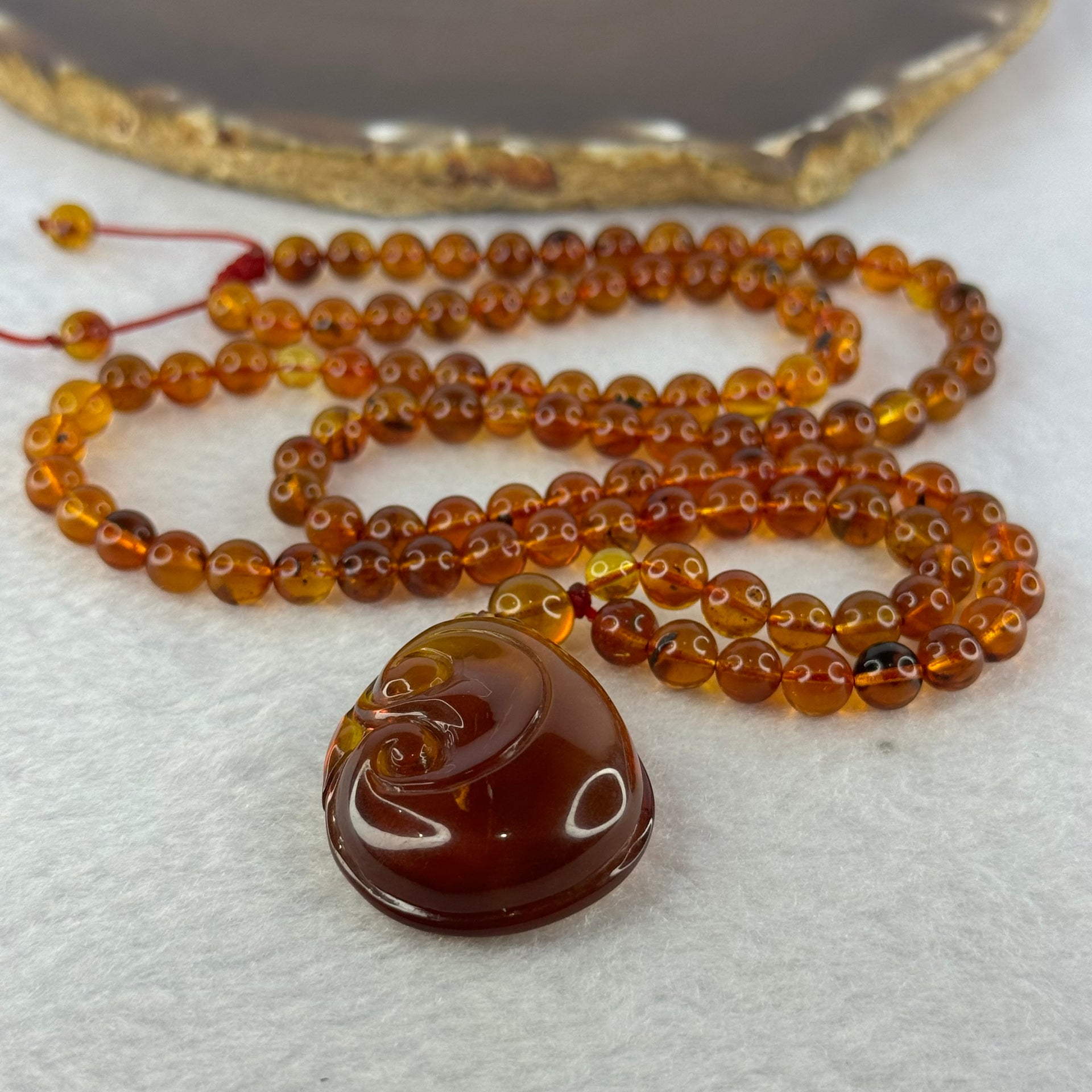 Natural Cognac Amber Ruyi Pendent 37.7 by 27.0 by 12.2mm in Amber Beads Necklace 6.3mm 105 Beads Total 19.80g - Huangs Jadeite and Jewelry Pte Ltd
