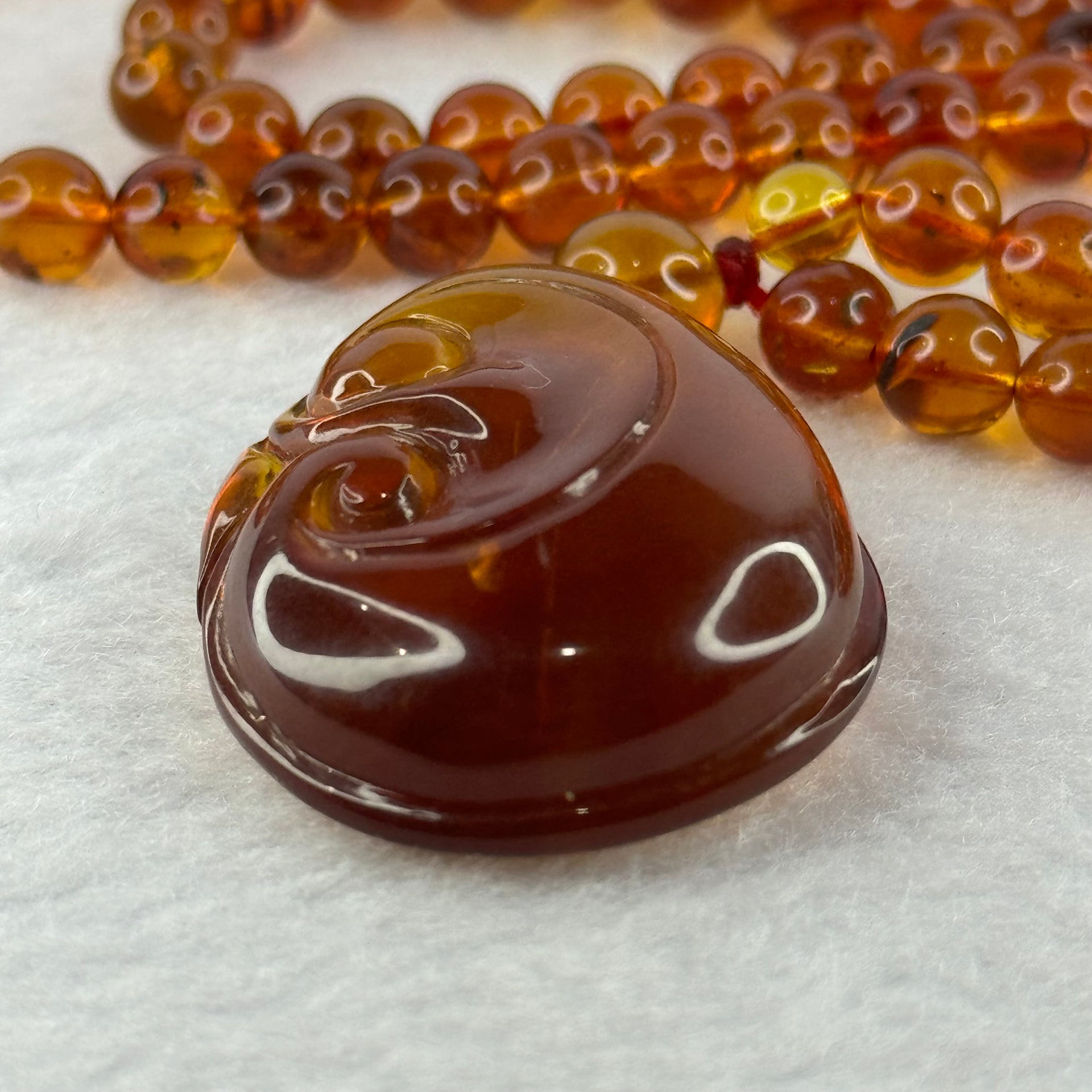 Natural Cognac Amber Ruyi Pendent 37.7 by 27.0 by 12.2mm in Amber Beads Necklace 6.3mm 105 Beads Total 19.80g - Huangs Jadeite and Jewelry Pte Ltd