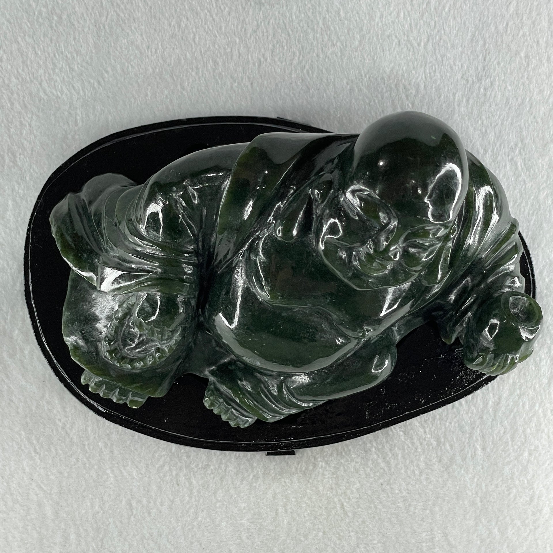 Natural Dark Green Serpentine Laughing Milo Buddha with Wealth Pot with Wooden Stand Display 1,656.6g 190.0 by 133.0 by 127.0mm - Huangs Jadeite and Jewelry Pte Ltd