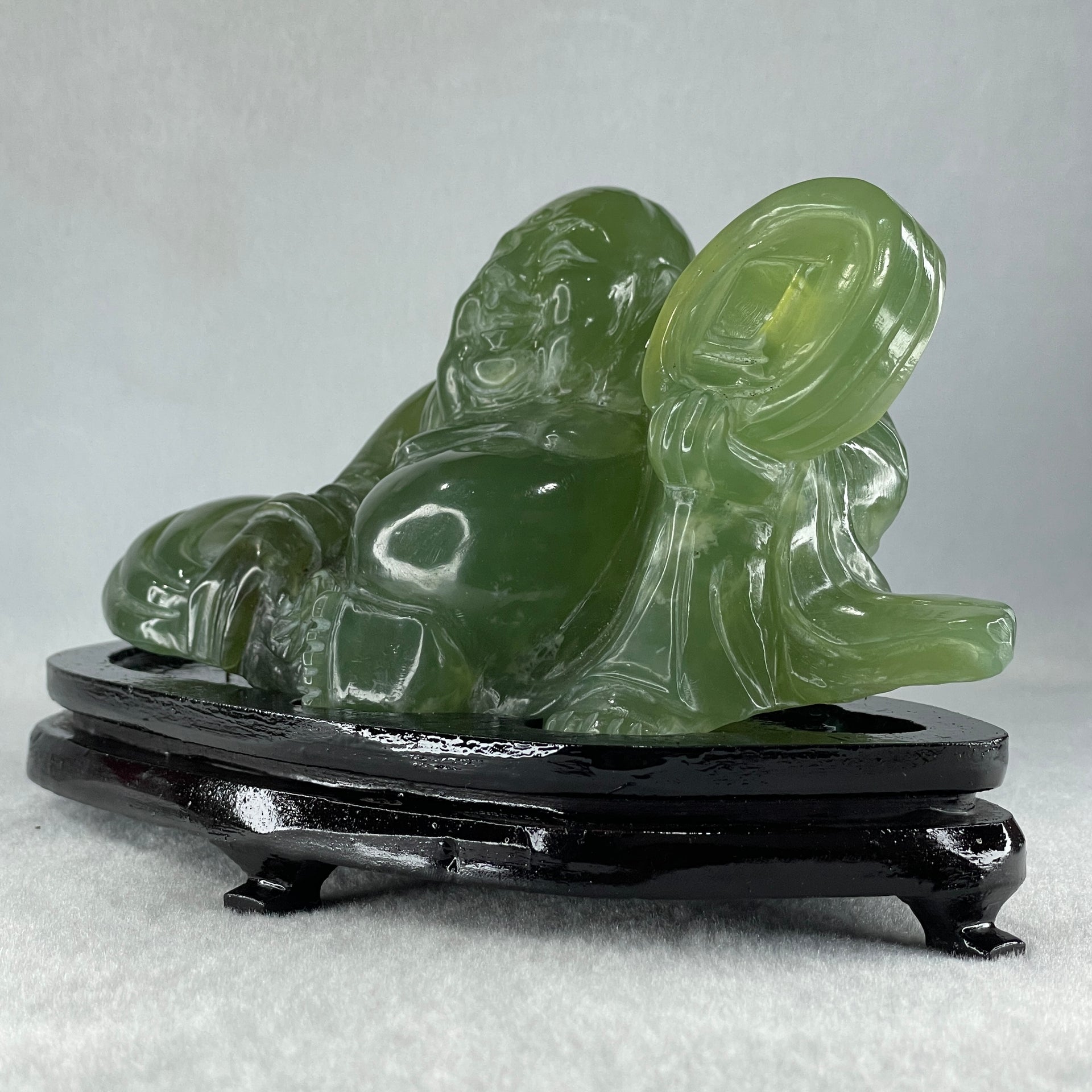 Natural Green Serpentine Siting Milo Buddha with Coin with Wooden Stand Display 1014.8g 200.0 by 100.0 by 105.0mm - Huangs Jadeite and Jewelry Pte Ltd