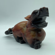 Red translucent jade Pixiu figurine displayed upright, showing detailed carving