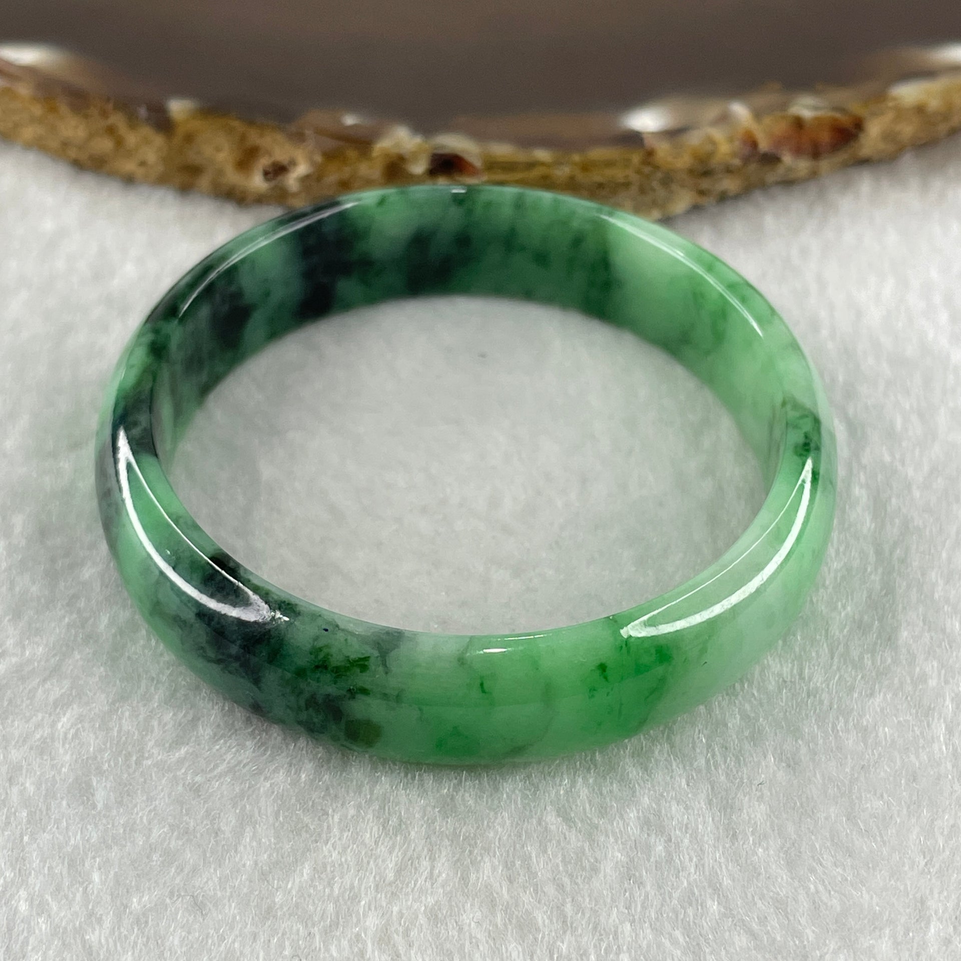 Type A Natural Old Mine Spicy Green with Dark Green Piao Hua Flora Jadeite Oval Bangle 26.28g 131.60cts Inner Diameter 52.55mm 46.90 by 5.40mm with NGI Cert 63804952 (Very Very Slight Internal Lines) - Huangs Jadeite and Jewelry Pte Ltd