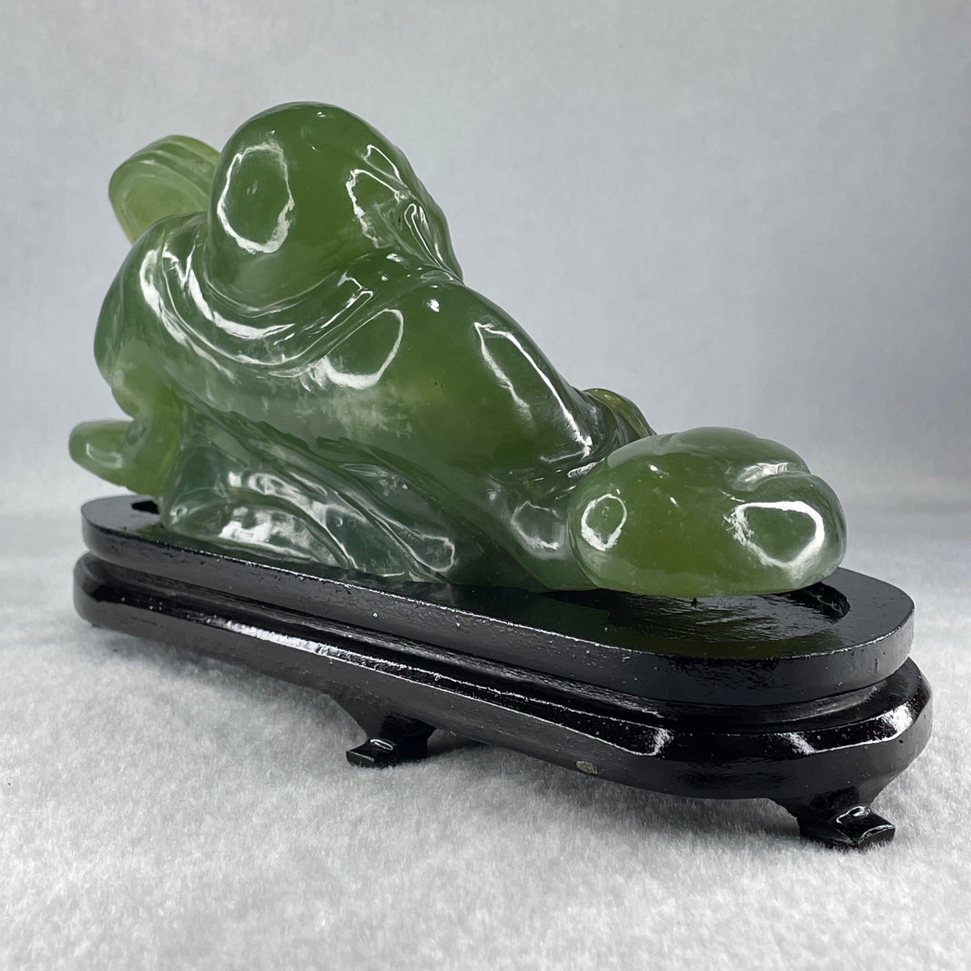 Natural Green Serpentine Siting Milo Buddha with Coin with Wooden Stand Display 1014.8g 200.0 by 100.0 by 105.0mm - Huangs Jadeite and Jewelry Pte Ltd