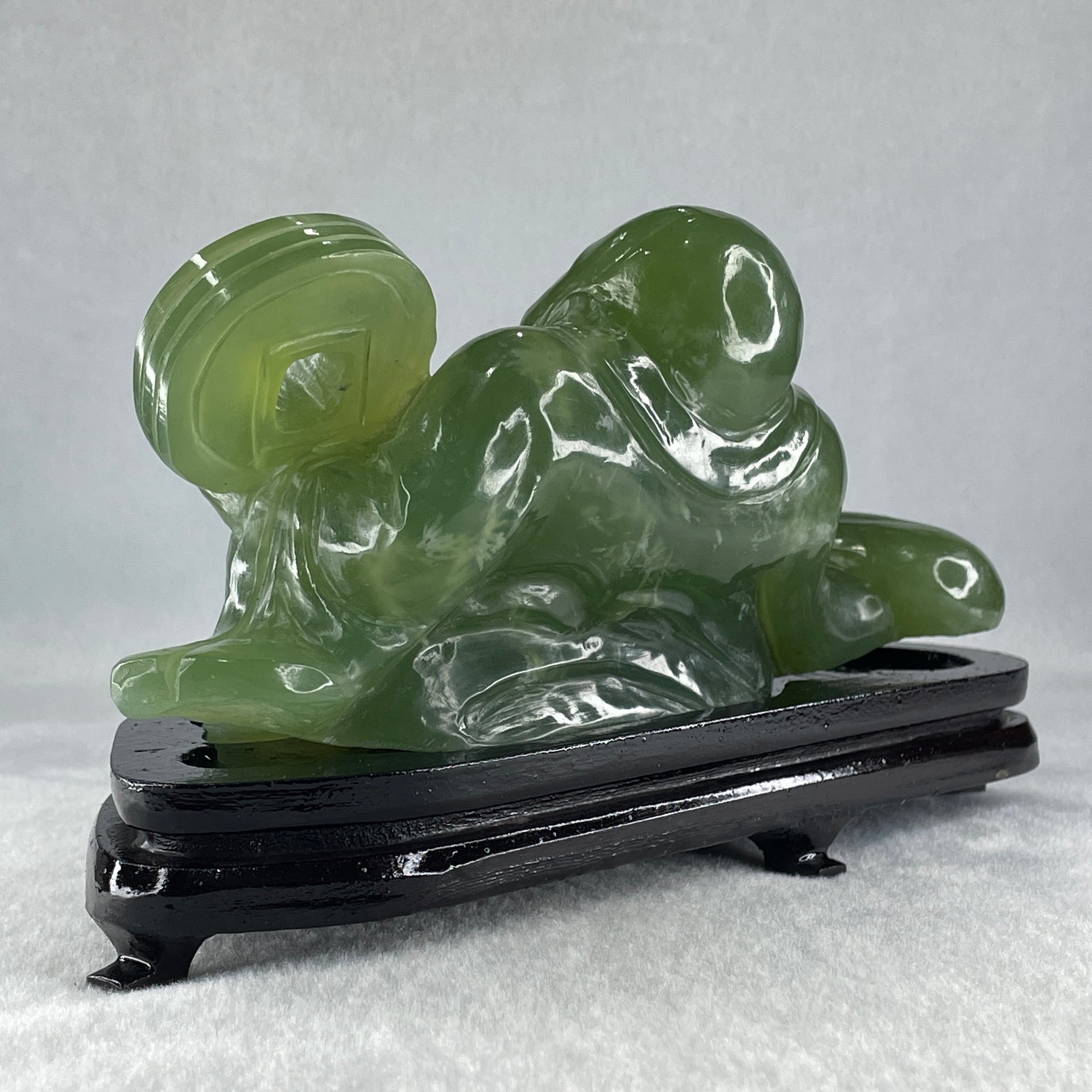 Natural Green Serpentine Siting Milo Buddha with Coin with Wooden Stand Display 1014.8g 200.0 by 100.0 by 105.0mm - Huangs Jadeite and Jewelry Pte Ltd