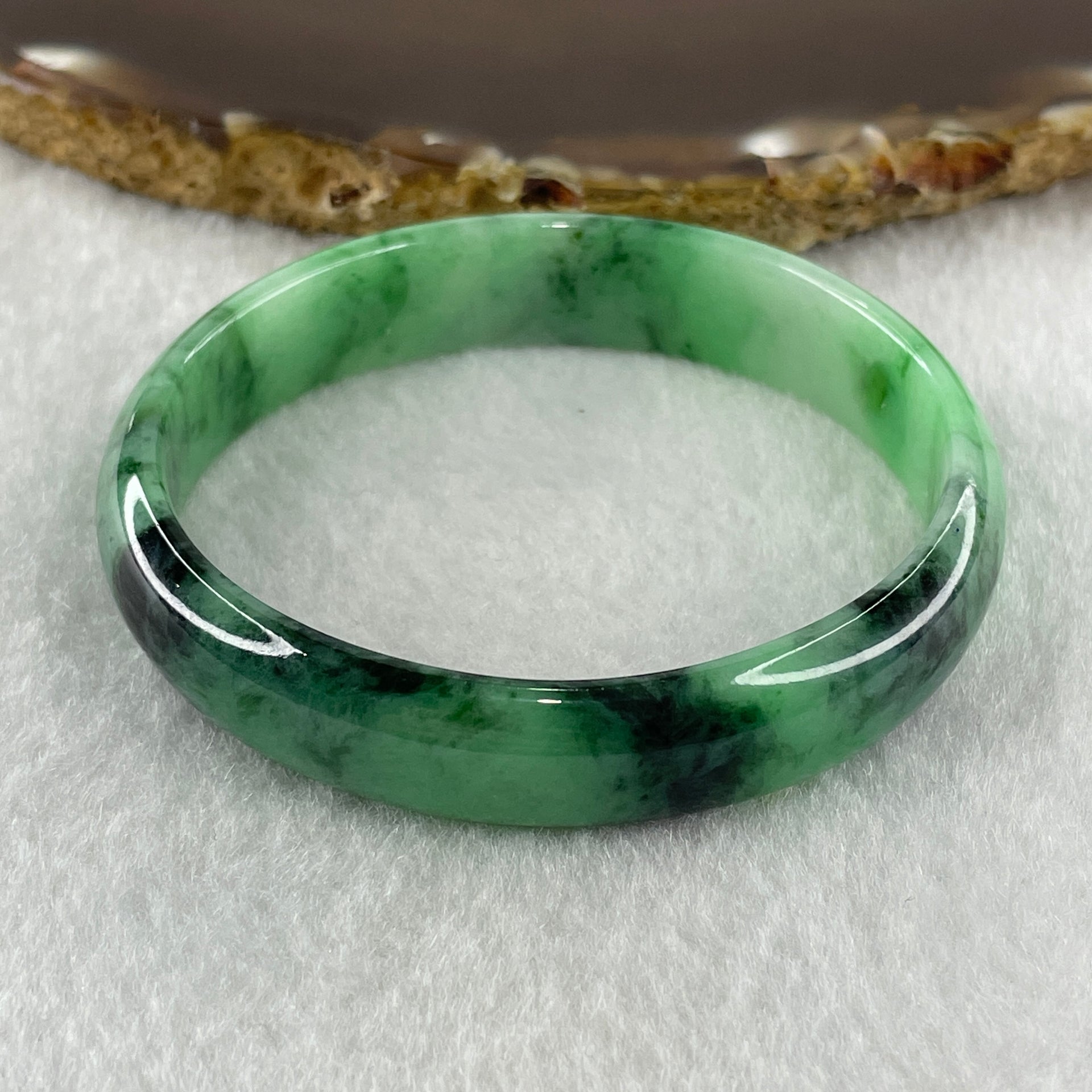 Type A Natural Old Mine Spicy Green with Dark Green Piao Hua Flora Jadeite Oval Bangle 26.28g 131.60cts Inner Diameter 52.55mm 46.90 by 5.40mm with NGI Cert 63804952 (Very Very Slight Internal Lines) - Huangs Jadeite and Jewelry Pte Ltd