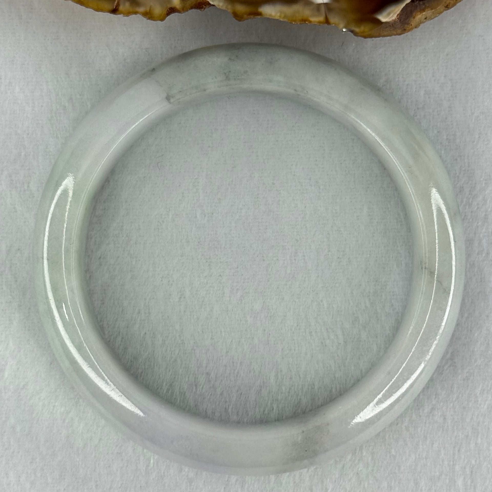 Type A Translucent Faint Blueish Green with Patches of Light Grey and Faint Lavender Jadeite Bangle Internal Diameter 56.95mm 344.09cts 69.22g 14.6 by 8.9mm With NGI Cert No 32886054 (Very Slight Internal Line) - Huangs Jadeite and Jewelry Pte Ltd