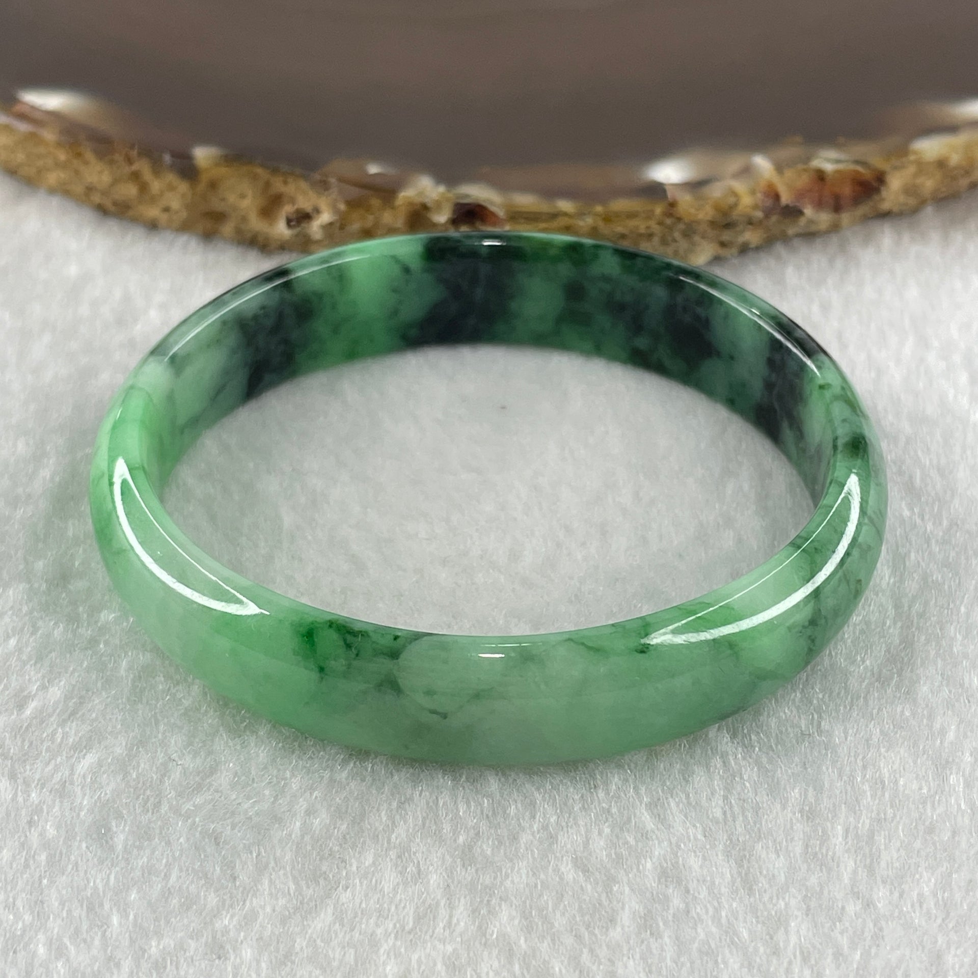 Type A Natural Old Mine Spicy Green with Dark Green Piao Hua Flora Jadeite Oval Bangle 26.28g 131.60cts Inner Diameter 52.55mm 46.90 by 5.40mm with NGI Cert 63804952 (Very Very Slight Internal Lines) - Huangs Jadeite and Jewelry Pte Ltd